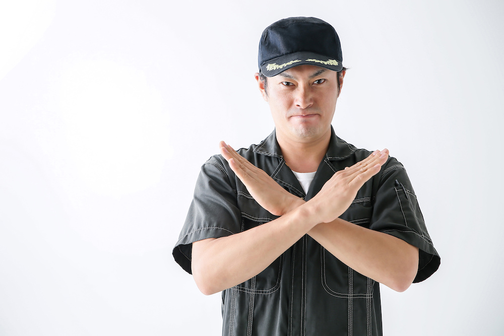 腕をバツを描くようにクロスする男性